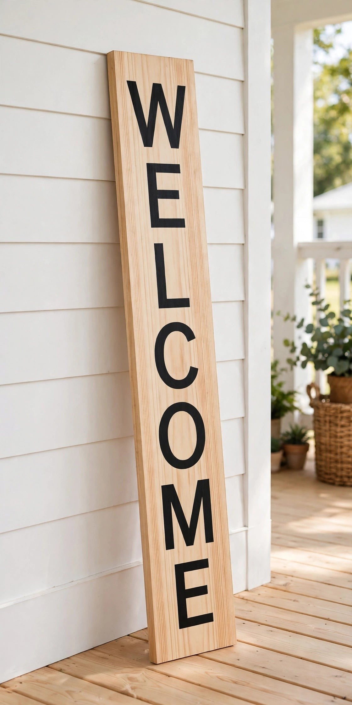 Keepsake lane vertical wooden welcome porch sign with bold black lettering leaning against a white farmhouse wall